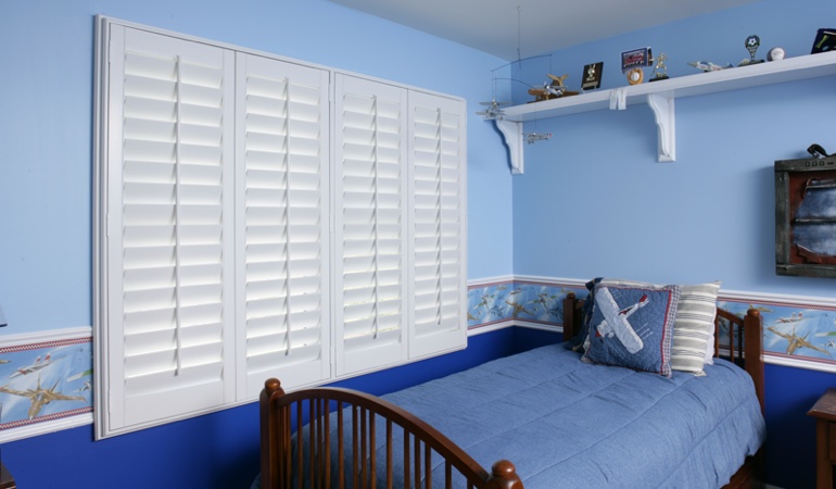 Blue kids bedroom with white plantation shutters in Destin 